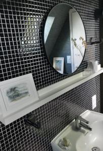 bagno con specchio e lavandino di La Chambre d'Agapè a Fouesnant