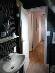 un bagno con lavandino, specchio e corridoio di La Chambre d'Agapè a Fouesnant