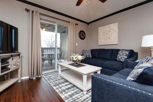 ein Wohnzimmer mit einem blauen Sofa und einem TV in der Unterkunft Beautifully Updated w Indoor Pool & Splash Pad Access in Branson