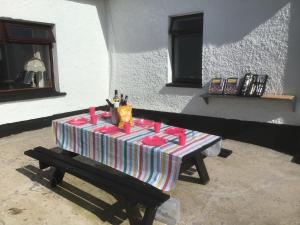a table with a striped table cloth on a bench at Teasy's cottage in Armagh