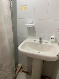 a bathroom with a white sink and a shower at Quyllur Ancestral in San Pedro de Atacama