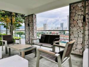 a patio with chairs and a table and a couch at Urban Suites Georgetown New Condo City View 158 in Jelutong