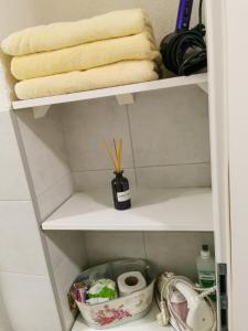- une étagère dans une salle de bains pourvue de serviettes dans l'établissement Apartment Miris Dunja, à Sarajevo 9 autres photos