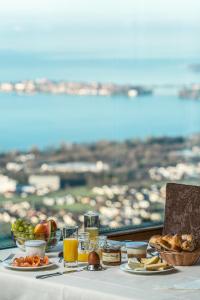 a table with breakfast food and a view of the ocean at Hotel Schönblick in Lochau