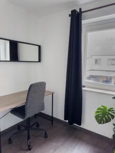 ein Büro mit einem Schreibtisch, einem Stuhl und einem Fenster in der Unterkunft Huisaanzee in Ostende