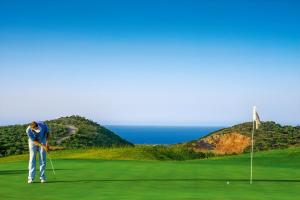 a man is playing golf on a golf course at 4 Seasons villa-Sea view in Hersonissos