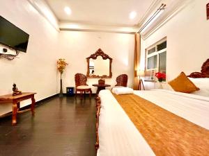 a hotel room with a large bed and a mirror at Sanju Lodge in Hisār