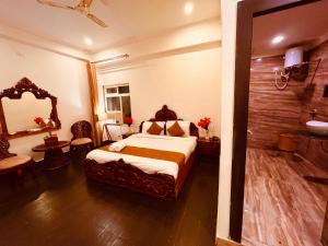 a hotel room with a bed and a bathroom at Sanju Lodge in Hisār