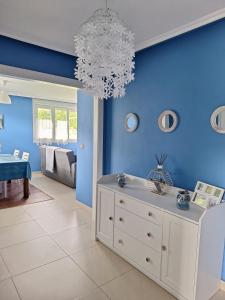 een woonkamer met blauwe muren en een kroonluchter bij Casina verde manzana in Villaviciosa