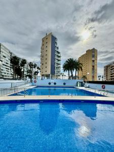 a large blue swimming pool with buildings in the background at Hipocampos in Calpe