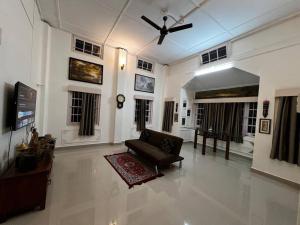a living room with a couch and a ceiling fan at Palm715 Villa in jorhat in Jorhāt