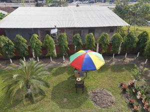 un ombrello colorato seduto in cima a un cortile di Palm715 Villa in jorhat a Jorhāt