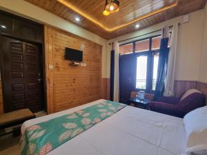 a bedroom with a bed and a tv and a window at Smart Valley Dalhousie in Dalhousie