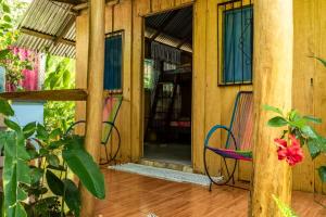 Los Paniquines Ecolodge في دريك: شرفة مع كرسي ومبنى