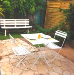una mesa de picnic y sillas con un banco en un patio en Studio in villa with parking and private garden, en Saint-Laurent-du-Var
