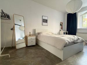 a bedroom with a white bed and a mirror at Studio G06 in Zagreb