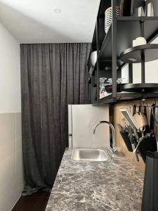 a kitchen with a sink and a black curtain at Studio G06 in Zagreb