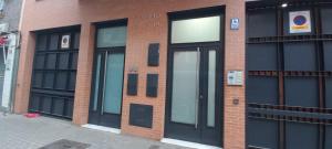 - un bâtiment en briques avec des portes et des fenêtres noires dans l'établissement APARTAMENTO TRIANA, à Séville