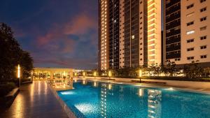 a large swimming pool in a city at night at Mirzas Alanis in Sepang