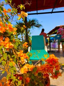 una silla azul sentada junto a unas flores naranjas en La Viduka Hostel en Cartagena de Indias