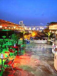 eine Dachterrasse mit Tischen und Stühlen in der Nacht in der Unterkunft La Viduka Hostel in Cartagena de Indias