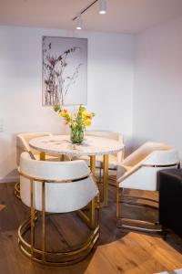 a table and chairs with a vase of flowers on it at Sope Skylodge 02 - Selina's & Gentjana's Kuckucksnest - Oberried, Schauinsland in Oberried