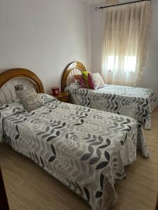 a bedroom with two twin beds and a window at 1001 maneras para endulzarte la vida in Porcuna