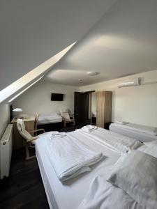 a hospital room with two beds and a table at HBH Bajor Sörház, Étterem és Panzió in Kazincbarcika