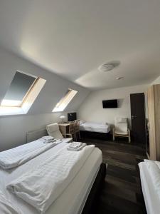 Habitación de hotel con 2 camas y TV en HBH Bajor Sörház, Étterem és Panzió en Kazincbarcika