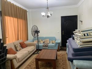 a living room with two couches and a fan at Marseilia blue bay asia in Ain Sokhna