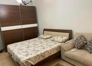 a small bedroom with a bed and a couch at Marseilia blue bay asia in Ain Sokhna