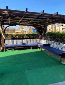 two blue benches sitting under a large umbrella at Marseilia blue bay asia in Ain Sokhna