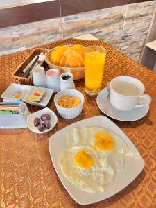 una mesa con un plato de huevos, café y bebidas en Jultom Inn Hotel & Suites, en Trujillo