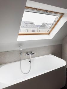ein Badezimmer mit einem Waschbecken und einem Dachfenster in der Unterkunft Huisaanzee in Ostende