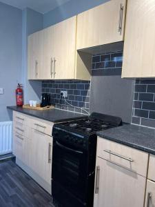 a kitchen with a black stove and white cabinets at AA Tyne Apartments in Gateshead