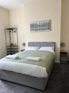a bedroom with a large bed with two towels on it at AA Tyne Apartments in Gateshead