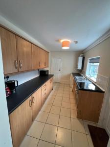 a large kitchen with wooden cabinets and black counter tops at AA Tyne Apartments in Gateshead