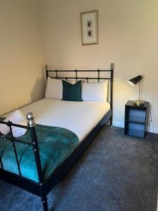 a bedroom with a bed with a black frame and a lamp at AA Tyne Apartments in Gateshead