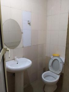 uma casa de banho com um lavatório, um WC e um espelho. em Light house hotel Lekki phase 1 em Lekki