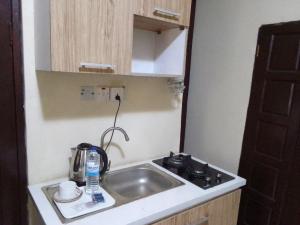 uma pequena cozinha com um lavatório e um fogão em Light house hotel Lekki phase 1 em Lekki