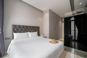 a bedroom with a large white bed with a hat on it at Mari Hotel By Connek in Ho Chi Minh City