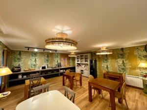 a kitchen and dining room with wooden tables and chairs at Posada El Corcal de Liébana in Tama