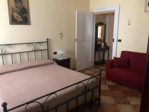 um quarto com uma cama e um sofá vermelho em B&b Sofia em Sannicandro Garganico