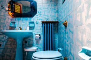 a blue bathroom with a toilet and a sink at La Casa dei Perci in Varenna