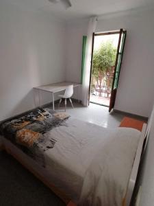 - une chambre avec un lit, un bureau et une fenêtre dans l'établissement Apartamento Universidad, à Ontinyent