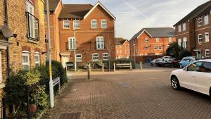 a white car parked in a parking lot next to brick buildings at San Pedro Lodge Sittingbourne in Kent