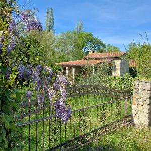 une clôture devant une maison ornée de fleurs violettes dans l'établissement Konoba DB, à Čapljina