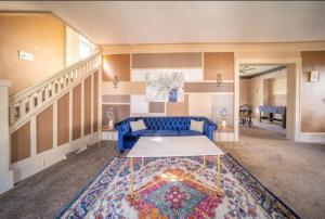 sala de estar con sofá azul y alfombra en 4 Bdrm in Highland Square, Akron, en Akron