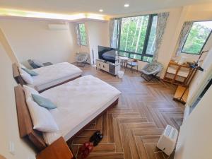 MeishanにあるRainy Pleasureのベッド2台、薄型テレビが備わる客室です。