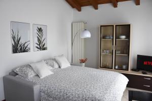 a bedroom with a bed and a desk and a television at CA' GIALLA 5 - sul Lago di Lugano, Dog friendly, Balcone & Parcheggio - in Cadegliano Viconago